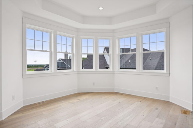 21412 Poate Ct, Rogers, MN 55374 - spare room featuring light wood finished floors, visible vents, baseboards, and a raised ceiling