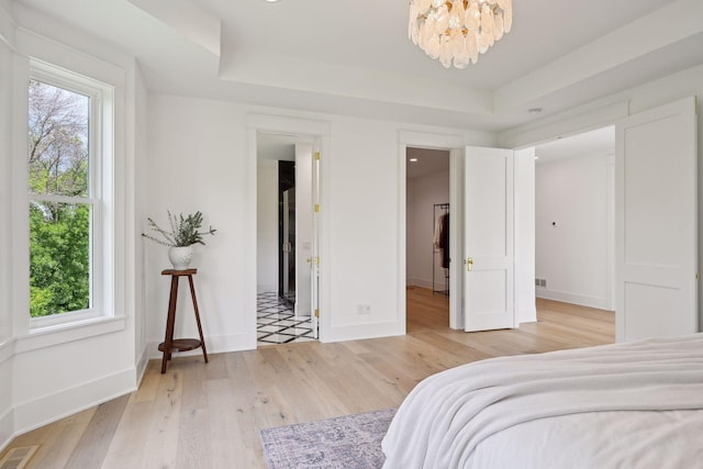 bedroom with multiple windows and light wood-type flooring