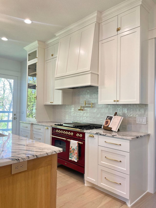 21412 Poate Ct, Rogers, MN 55374 - kitchen with custom exhaust hood, tasteful backsplash, light wood finished floors, and white cabinets