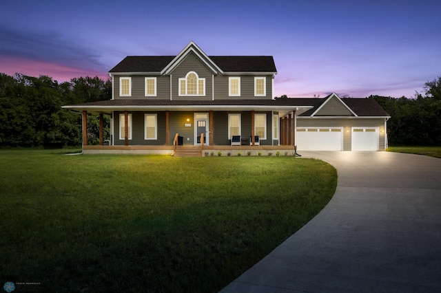 view of front of property featuring a porch, a garage, and a lawn