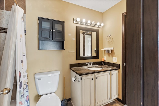 bathroom featuring walk in shower, vanity, and toilet