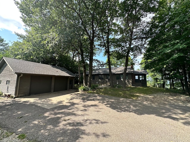 view of front of home with a detached garage and a shingled roof