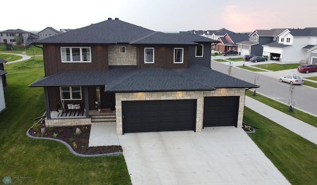 view of front facade featuring a garage, a yard, and covered porch