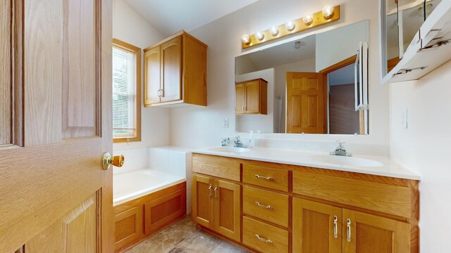 bathroom featuring vanity, a bath, and vaulted ceiling