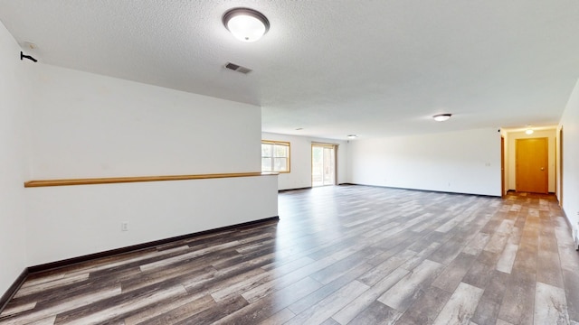 unfurnished room with dark hardwood / wood-style flooring and a textured ceiling