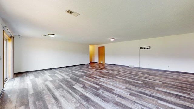 spare room with wood-type flooring and a textured ceiling