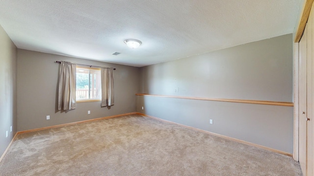 carpeted spare room featuring a textured ceiling