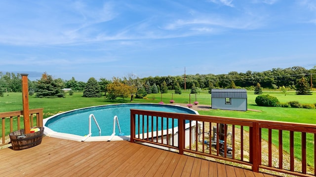 view of pool with a storage unit, a yard, and a wooden deck