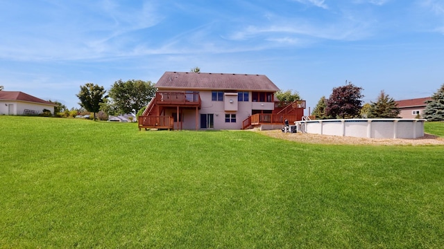 back of house featuring an outdoor pool, stairs, a deck, and a yard