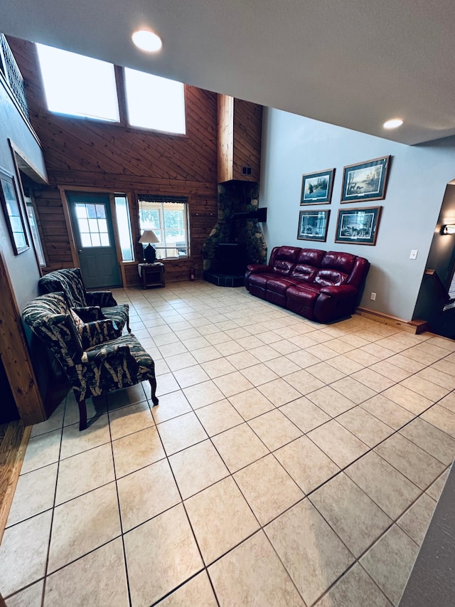 tiled living room featuring wood walls and a high ceiling