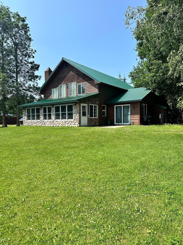 rear view of property with a lawn