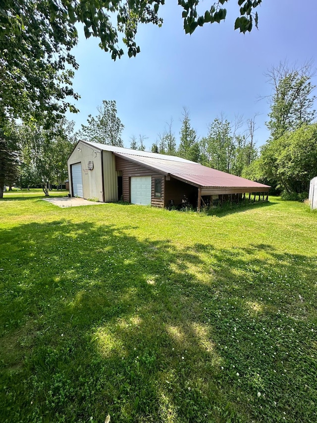 exterior space with a garage and a lawn