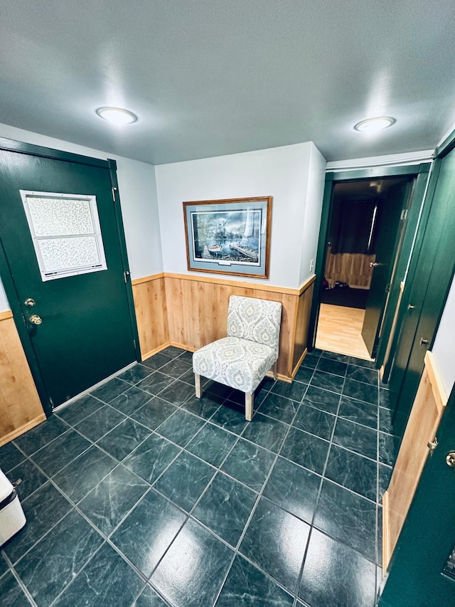 foyer featuring wooden walls and a textured ceiling