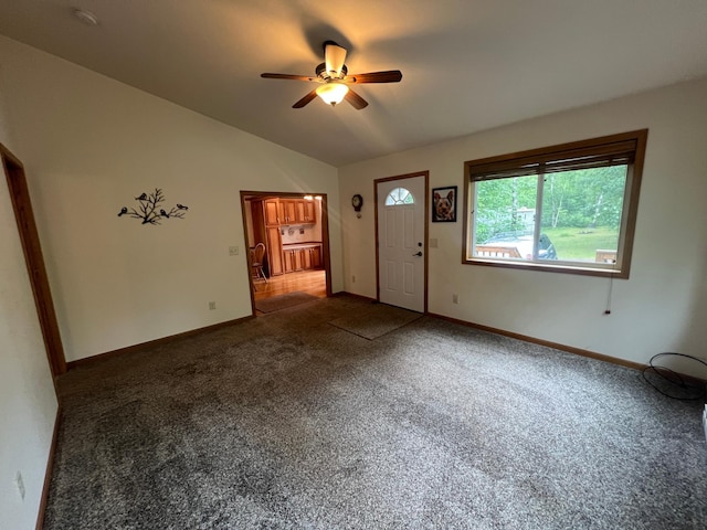 carpeted spare room featuring ceiling fan and vaulted ceiling