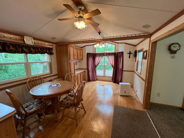 dining room with ceiling fan, ornamental molding, a textured ceiling, light wood-type flooring, and vaulted ceiling