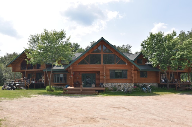 rear view of property featuring a deck and a lawn