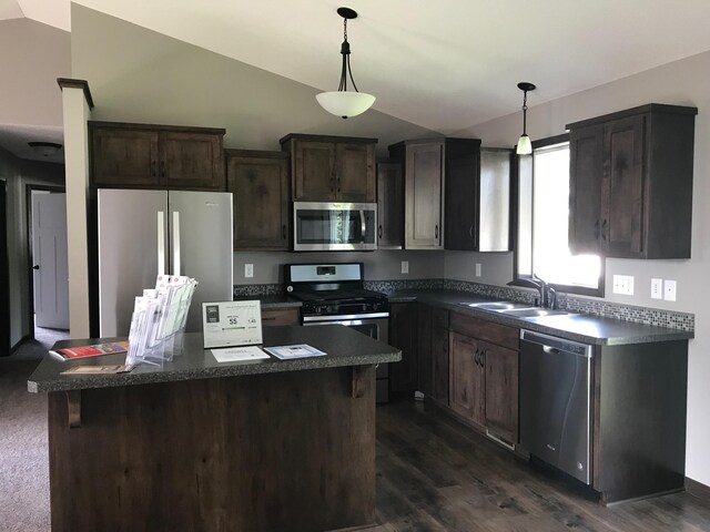 kitchen with lofted ceiling, dark colored carpet, appliances with stainless steel finishes, dark brown cabinetry, and sink