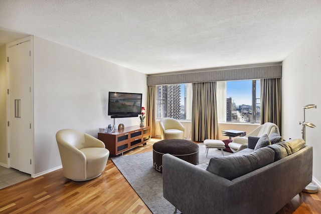 living area with a textured ceiling, wood finished floors, and a healthy amount of sunlight