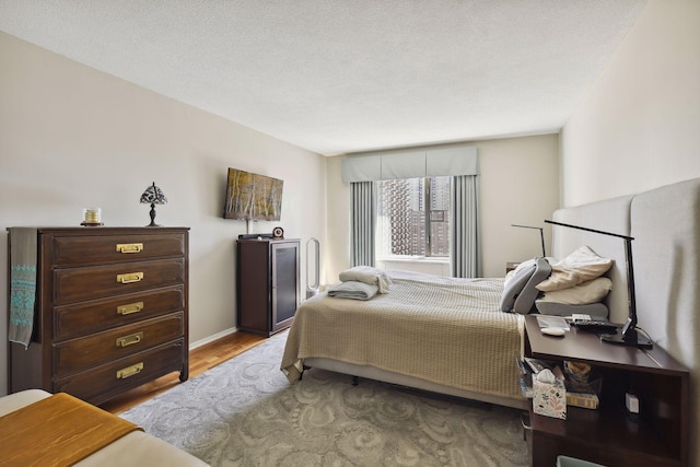 bedroom with light hardwood / wood-style flooring and a textured ceiling