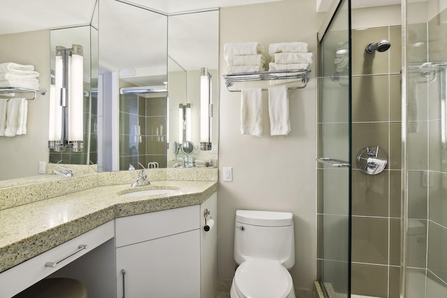 bathroom with a stall shower, vanity, and toilet