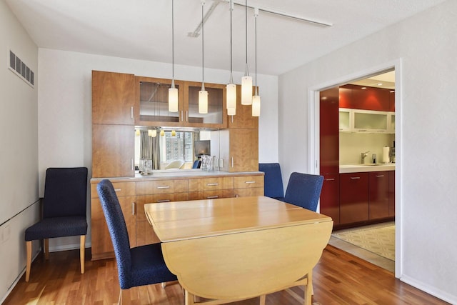 dining room with baseboards, light wood-style flooring, and visible vents