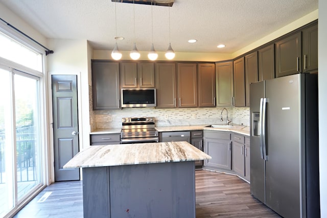 kitchen featuring hanging light fixtures, appliances with stainless steel finishes, sink, and plenty of natural light