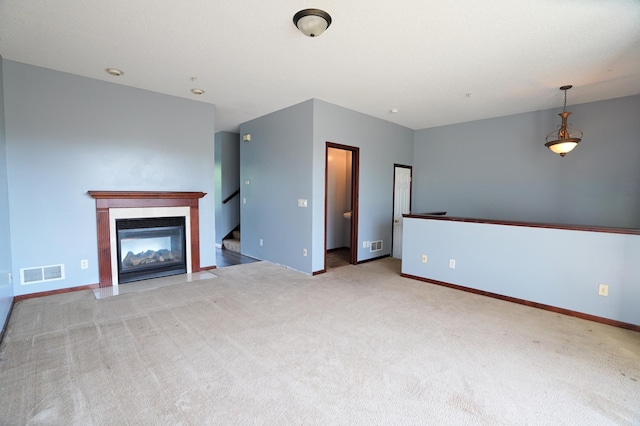 unfurnished living room with carpet floors and a fireplace