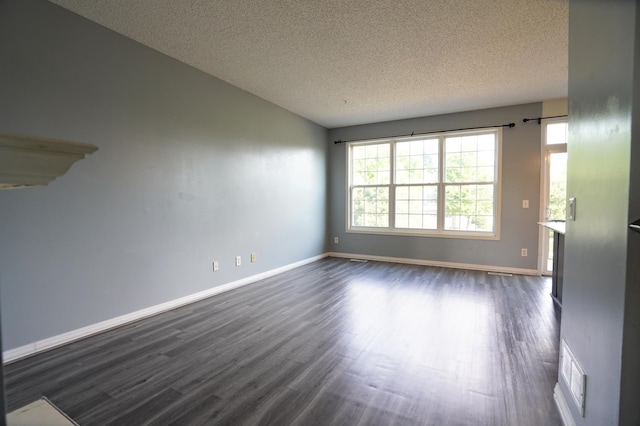 empty room featuring a textured ceiling and dark wood-type flooring