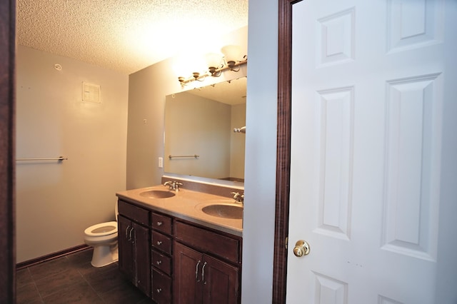 bathroom featuring tile patterned floors, double vanity, a textured ceiling, and toilet