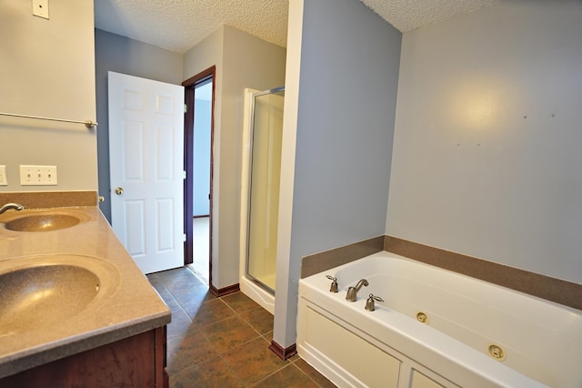 bathroom featuring tile patterned floors, plus walk in shower, a textured ceiling, and dual bowl vanity