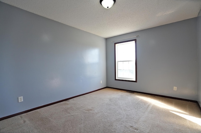 unfurnished room with carpet flooring and a textured ceiling