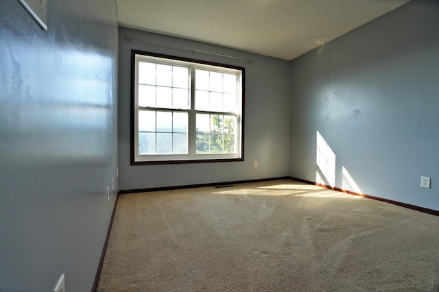 carpeted empty room with a textured ceiling