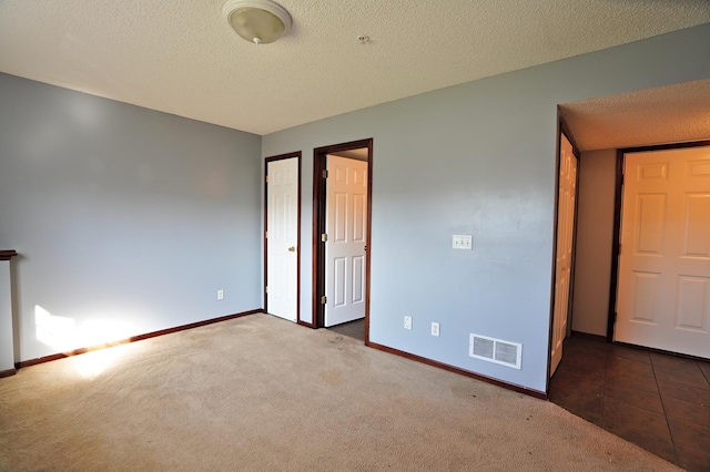 unfurnished bedroom featuring carpet and a textured ceiling