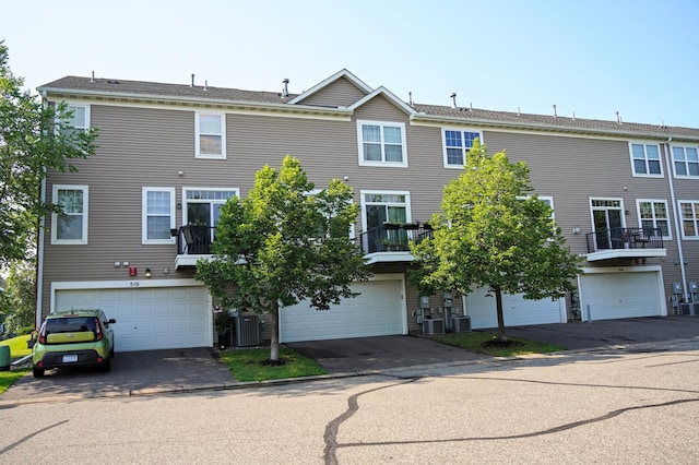 view of front of home featuring a garage, a balcony, and cooling unit