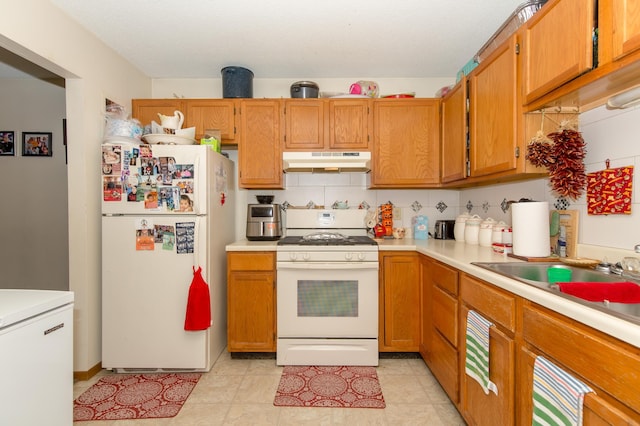 kitchen with tasteful backsplash, sink, and white appliances