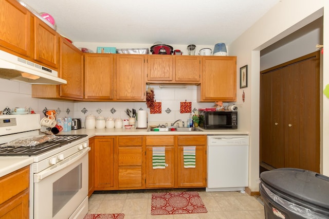 kitchen featuring white appliances, sink, and decorative backsplash