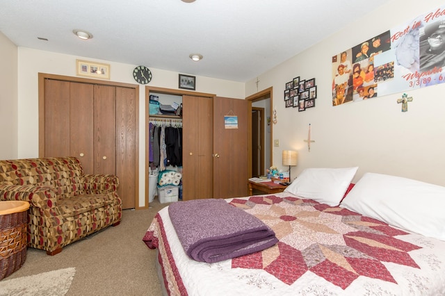 bedroom with multiple closets and light carpet