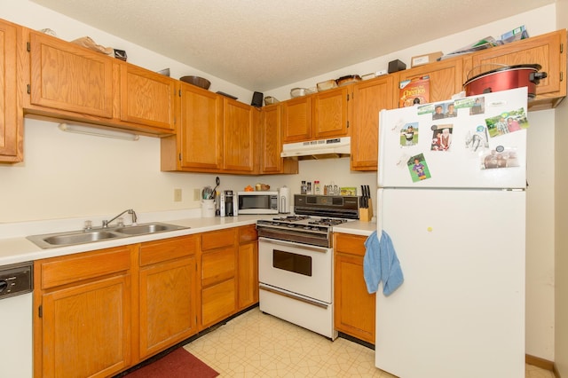 kitchen with sink, a textured ceiling, and white appliances