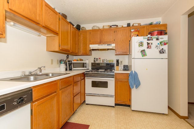 kitchen with sink, white appliances, and a textured ceiling