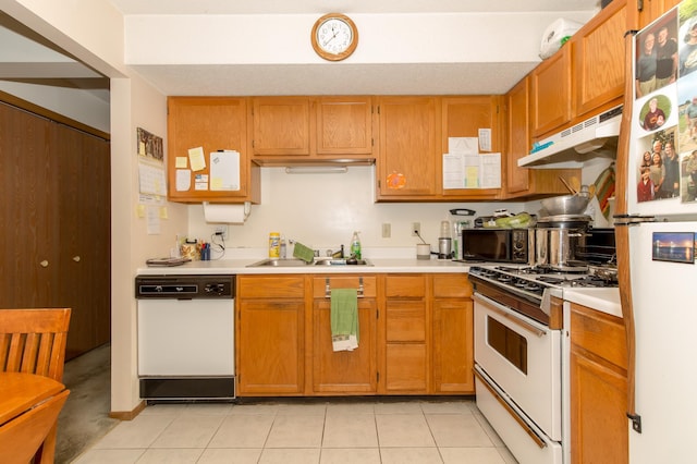 kitchen featuring sink, light tile patterned floors, and white appliances