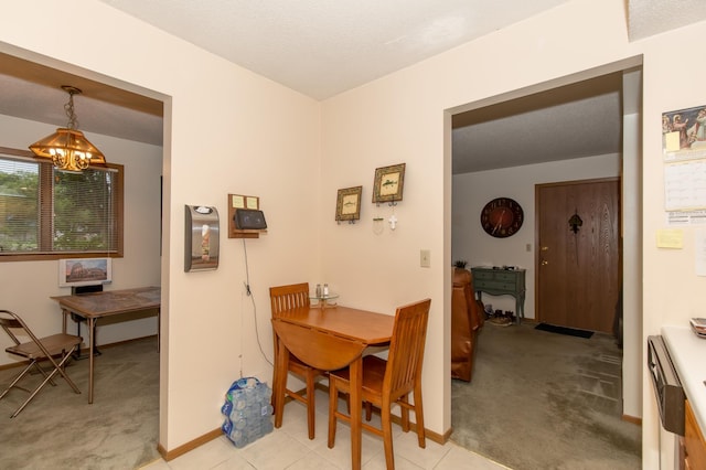 dining area featuring light colored carpet, a textured ceiling, and a notable chandelier