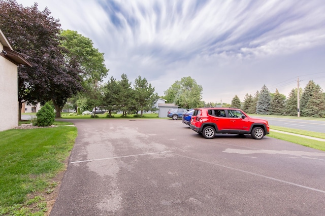 view of parking with a yard