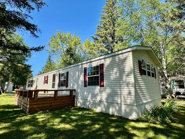 view of front of property featuring a deck and a front yard