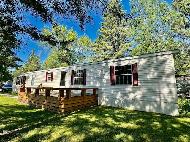 manufactured / mobile home with a front lawn and a wooden deck