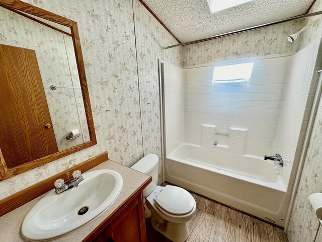 full bathroom featuring vanity, hardwood / wood-style floors, tub / shower combination, toilet, and a textured ceiling