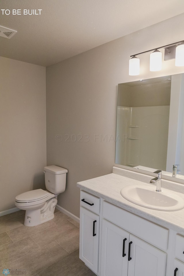 bathroom featuring vanity, a shower, and toilet