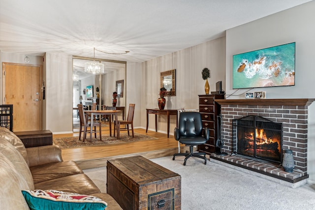 living room featuring a chandelier, a brick fireplace, and baseboards