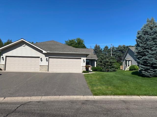 view of front facade with aphalt driveway, a garage, a shingled roof, and a front yard