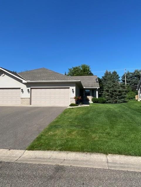 view of front facade with aphalt driveway, a garage, a front yard, and roof with shingles