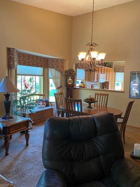 living room with carpet flooring, a towering ceiling, and a chandelier